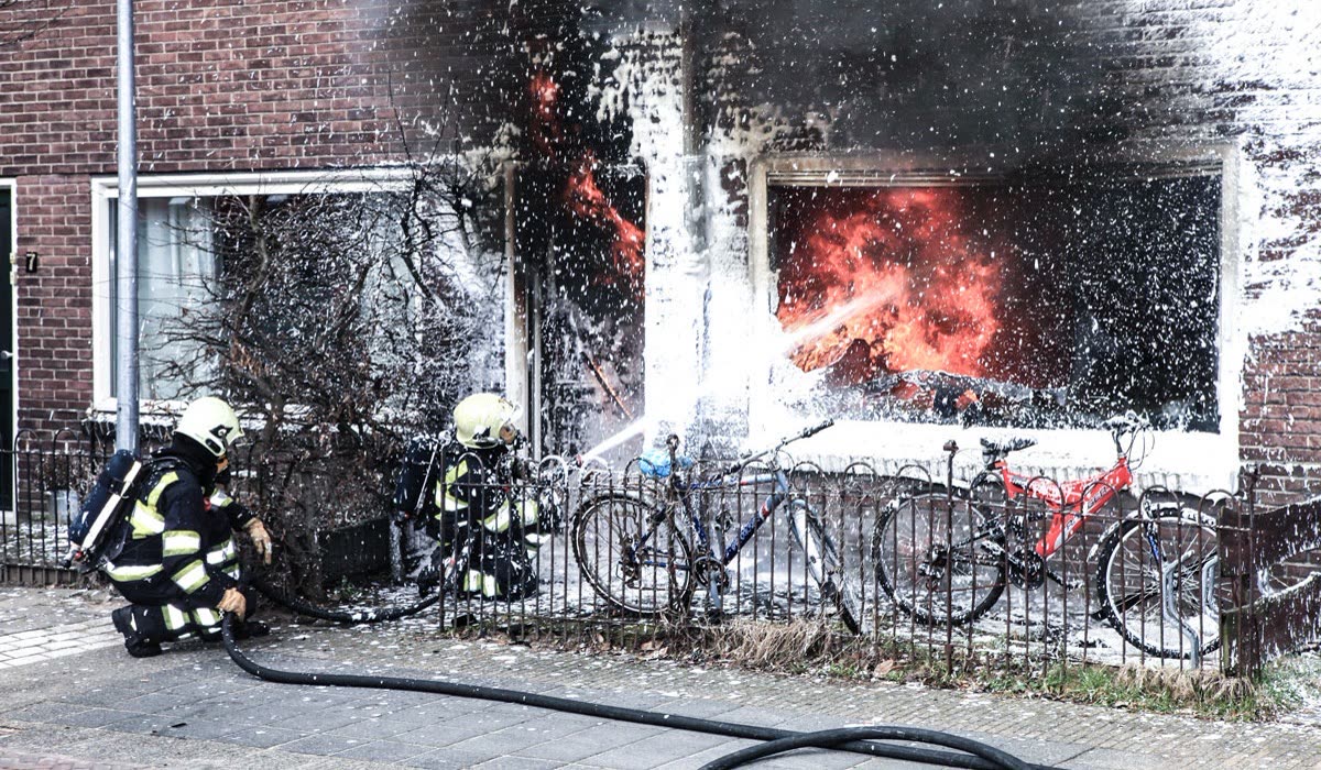 Feuerwehrleute löschen einen Wohnungsbrand mit Löschschaum