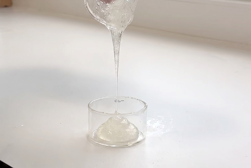 Teilhydratisiertes Schaummittel läuft zähflüssig und gelartig in ein Glas