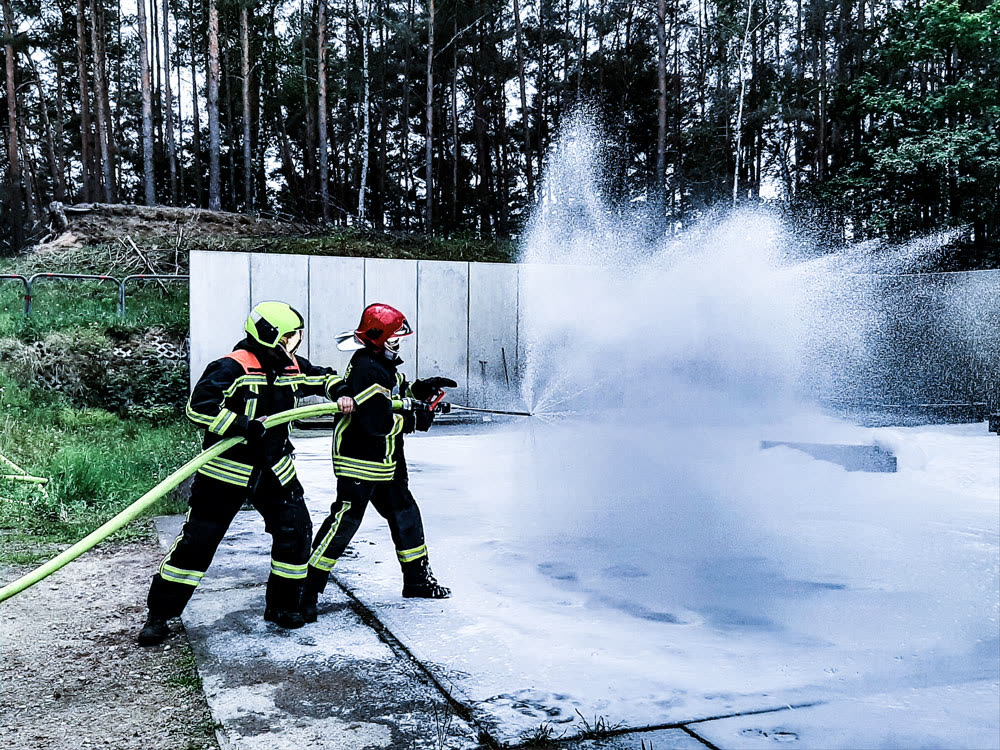 Zwei Feuerwehrleute bei einer Schulung mit Schaumstrahl
